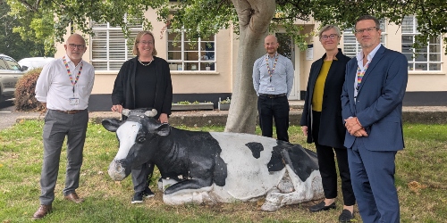 Staff members stood outside next to the model cow at Langford